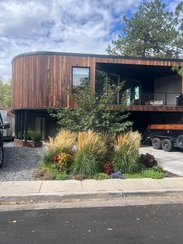 Finished curved cedar home exterior with landscaping